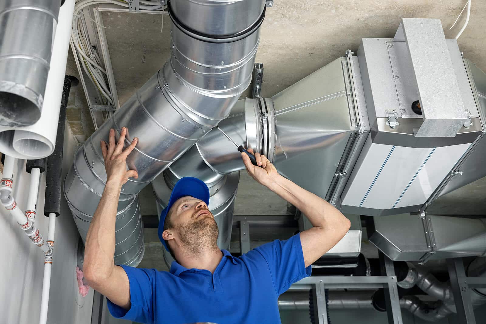 HVAC technician inspecting and repairing air ducts in Hayward