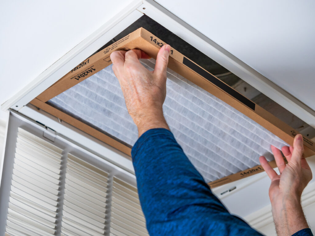 HVAC technician replacing a home air filter in Hayward