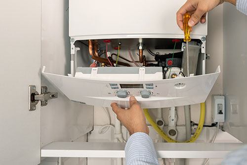Heating technician repairing a residential boiler in Hayward