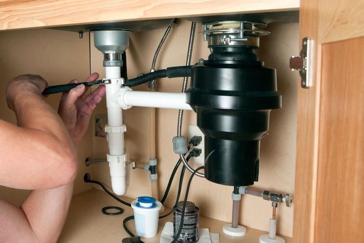Plumber repairing a garbage disposal in Hayward