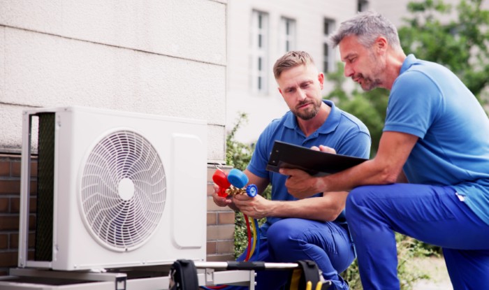 HVAC technicians installing an outdoor air conditioning unit in Hayward