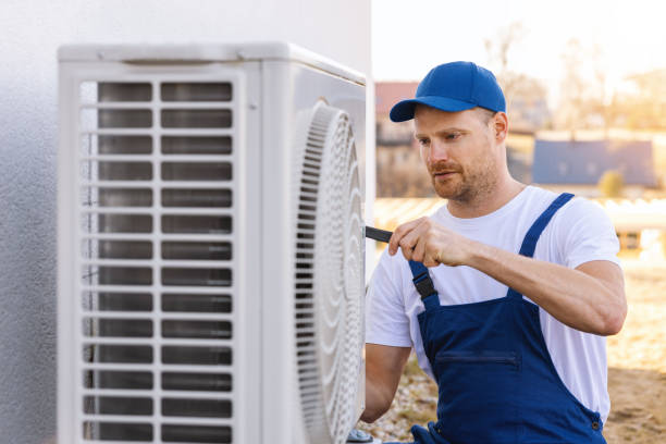 HVAC technician servicing an outdoor air conditioner in Hayward