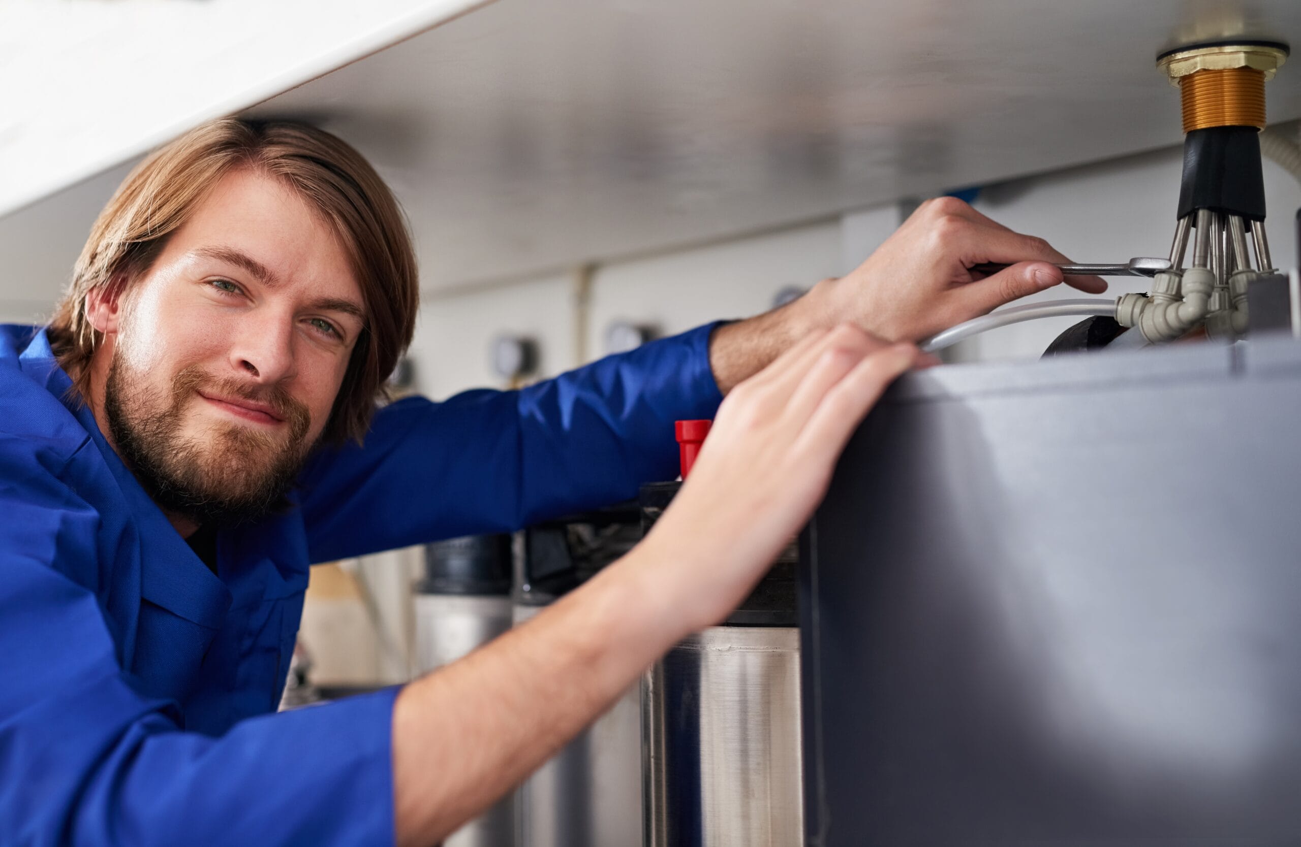 Technician servicing a residential water heater tank in Hayward